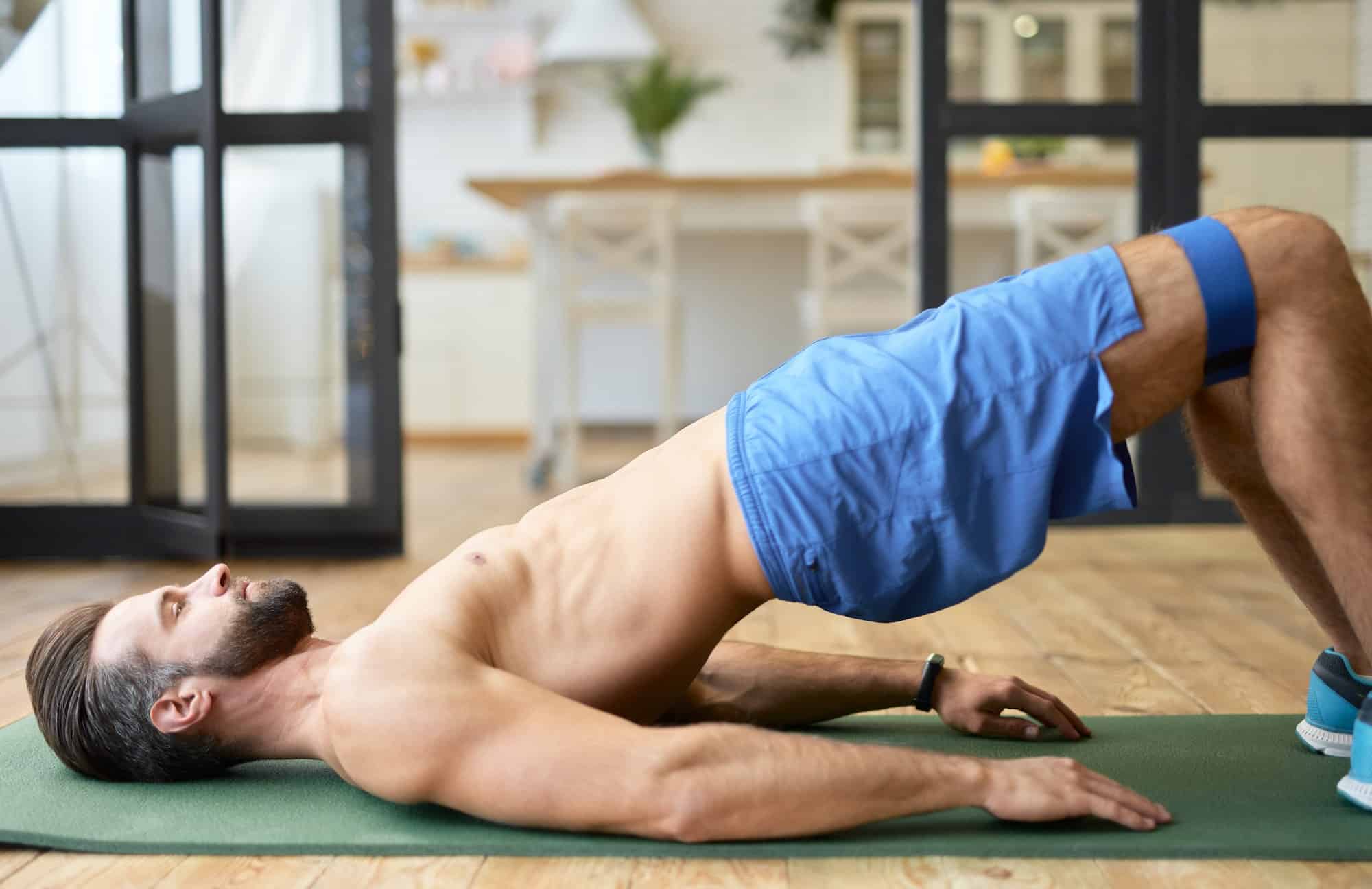 Bearded young man doing exercise with elastic fitness band